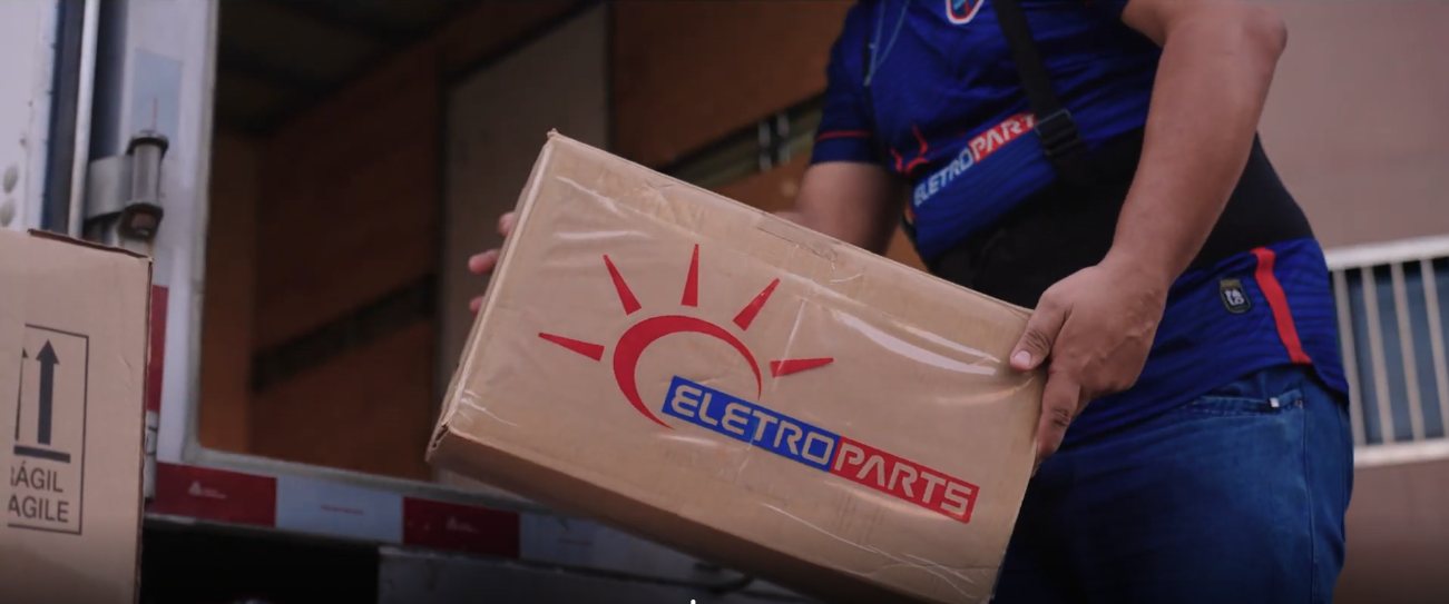 Colaborador da Eletroparts carregando uma caixa no caminhão de entregas